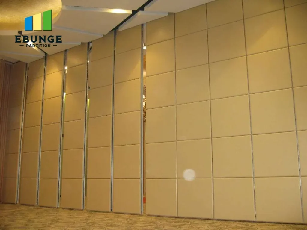 Modular beige partition panels with vertical metal rails in a conference room; EBUNGE Partition logo in the top-left corner.