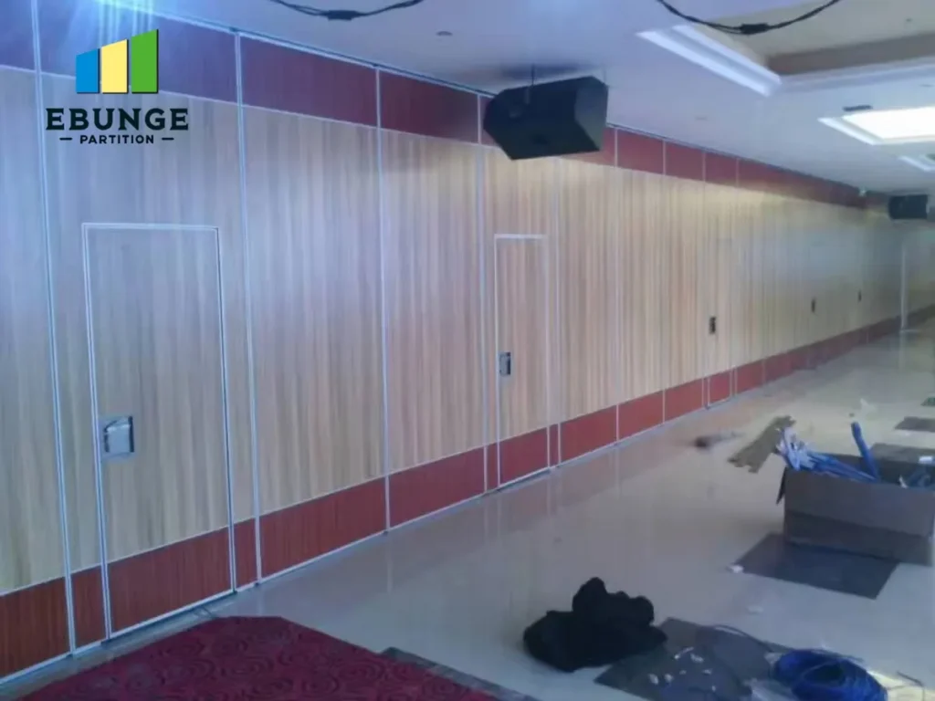 technician inspecting acoustic partition installation in school hall