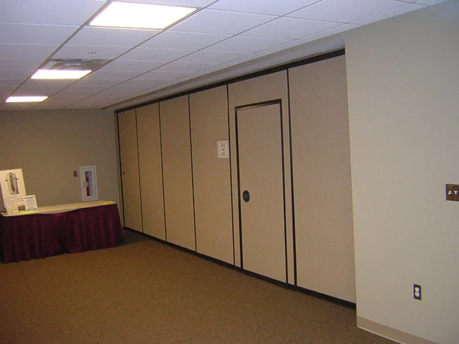 Closed movable partition wall with an inset pass door