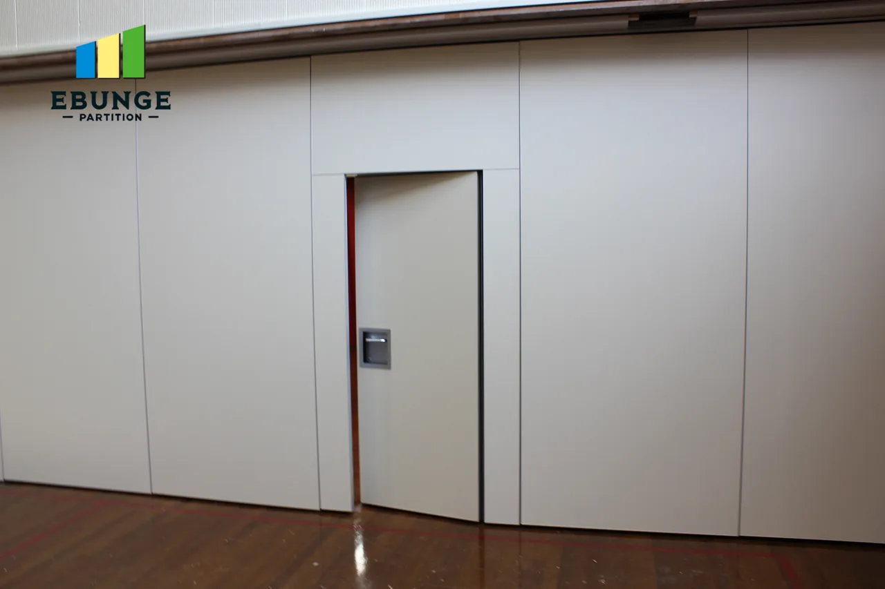 White movable partition with a partly open pass door