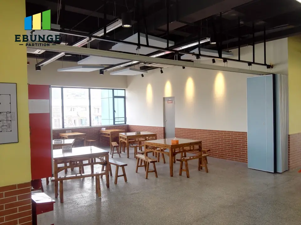 Movable partition overhead route crossing a room with exposed services
