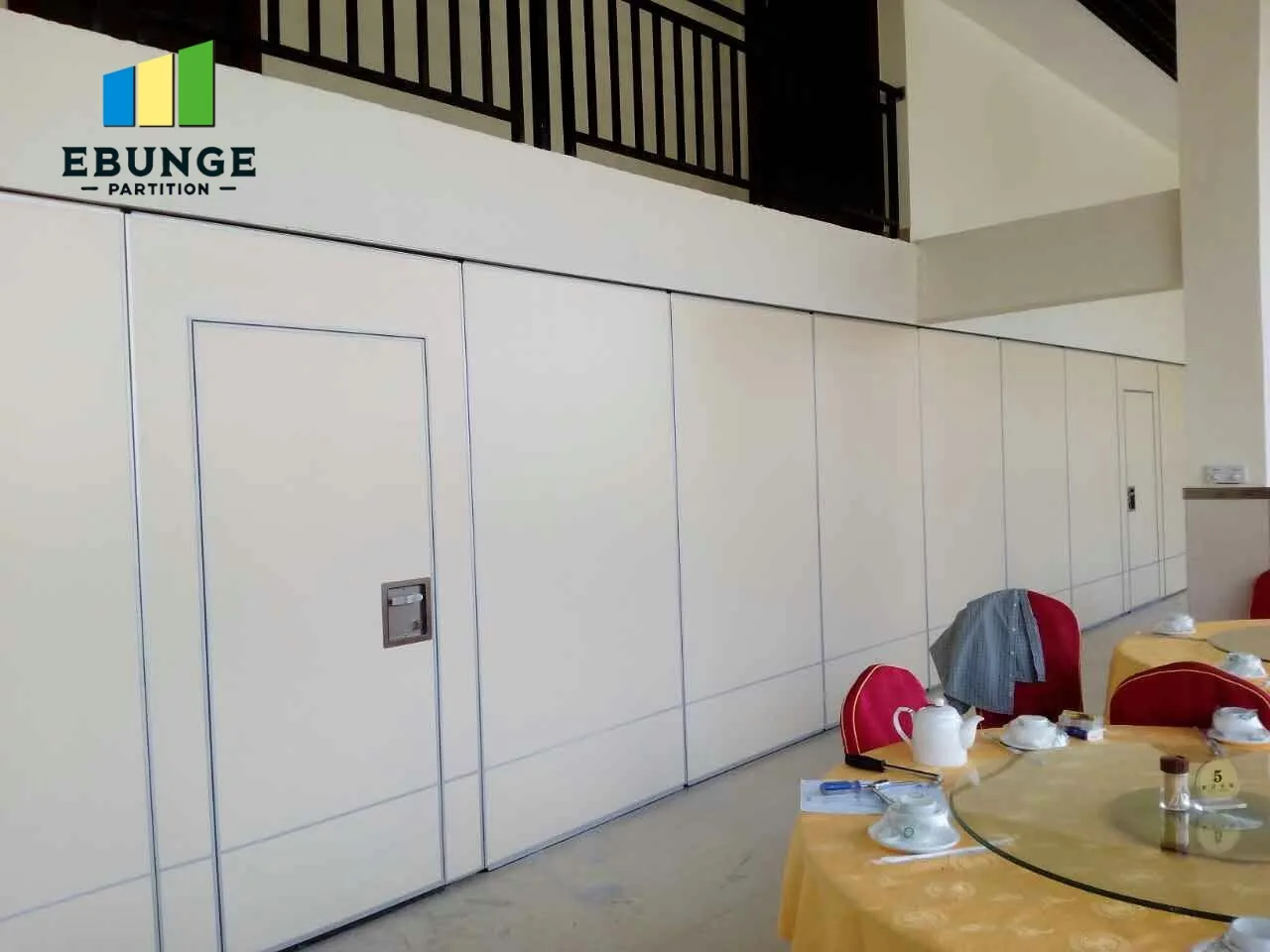 Real white movable partition with visible pass doors and recessed handles in a meeting room